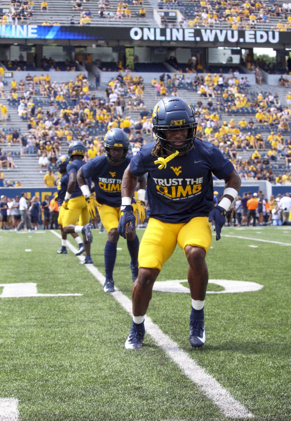 Members of the West Virginia football team go through pregame warmups.